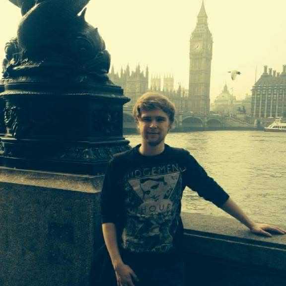 Lewis standing on a bridge over the Thames River, with Big Ben visible in the background